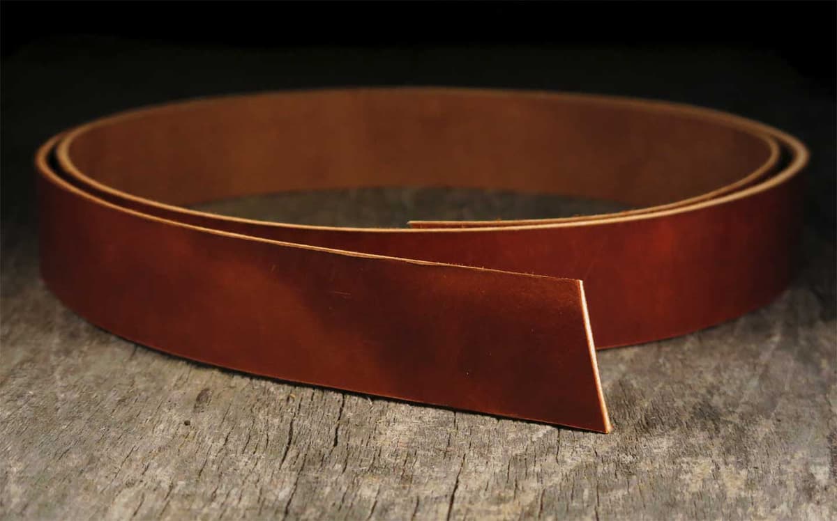 Leather belt making tools and materials on a workbench